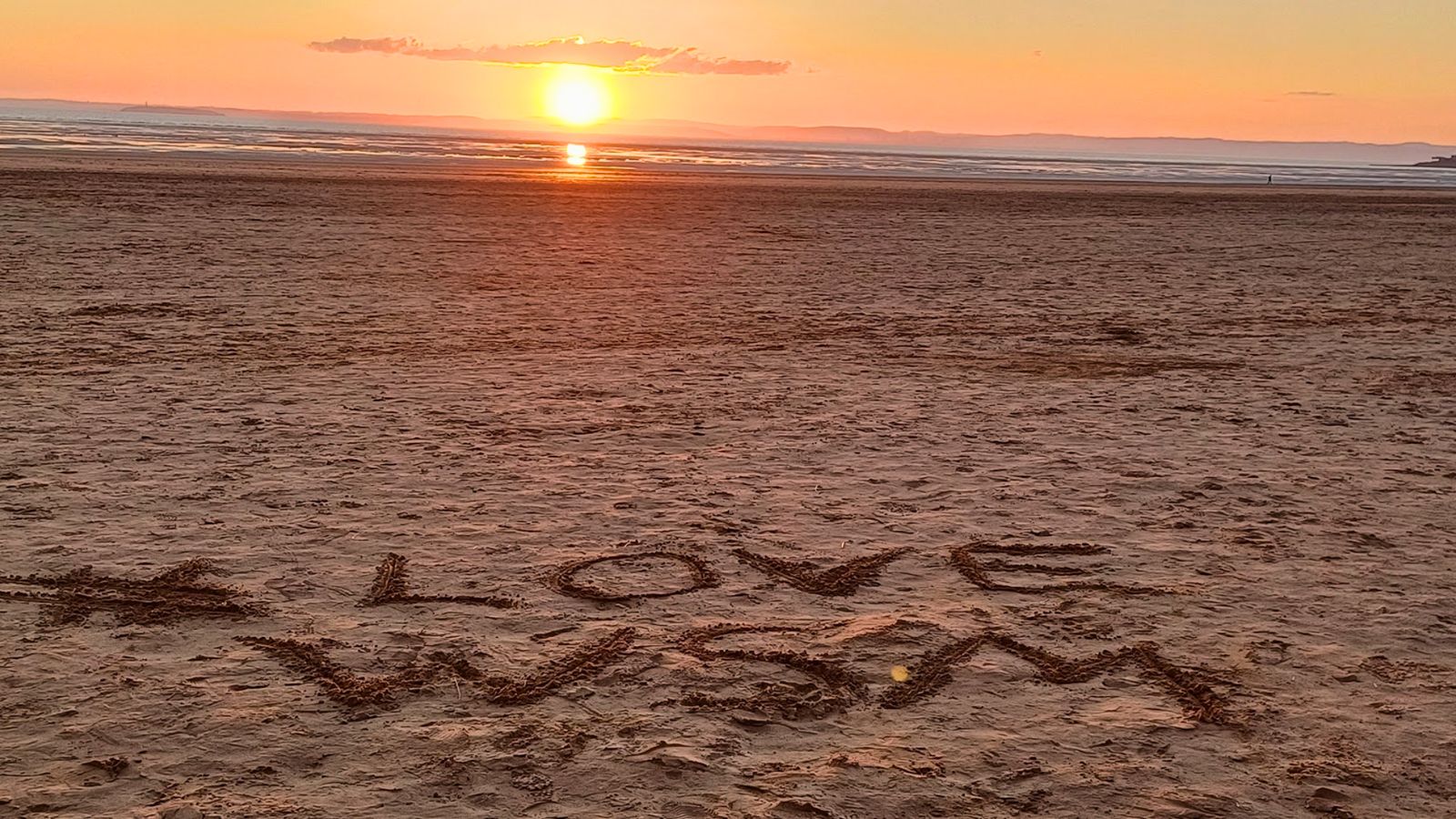 'I love WSM' written in the sand at sunset on Weston beach